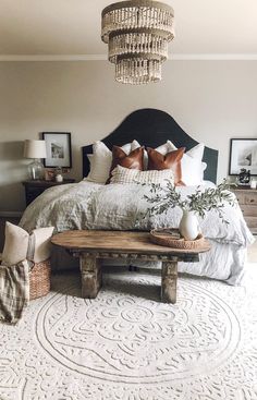 a bedroom with a large bed and chandelier hanging from the ceiling