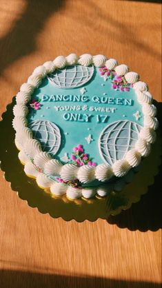 a cake that is sitting on top of a wooden table with the words, dancing queen you're sweet only 17