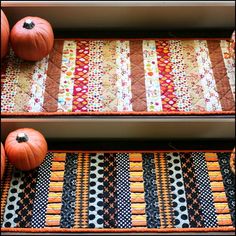 two pumpkins sitting on top of a table next to some quilted placemats