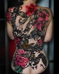 the back of a woman's body with tattoos on it