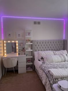 a bedroom with lights on the wall and a bed in front of a mirror that has been lit up