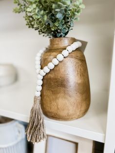 a vase filled with flowers and beads on top of a table