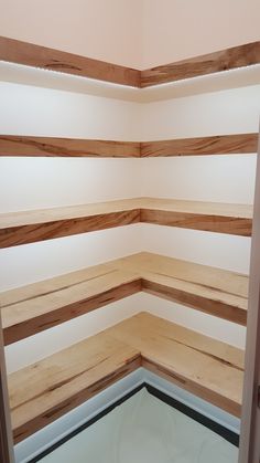 the corner of an empty room with wood slats on the walls and flooring