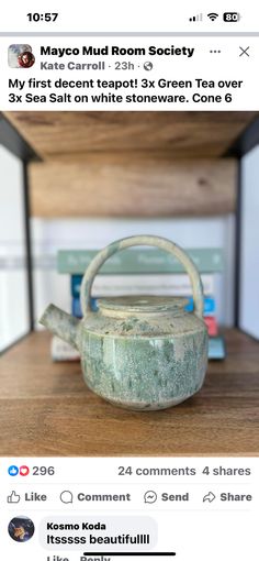 an old tea kettle sitting on top of a wooden table