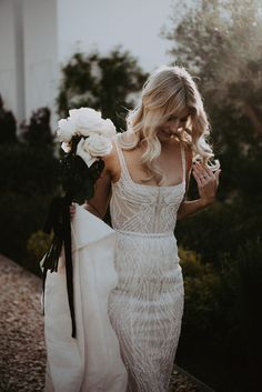 a woman in a white dress holding flowers