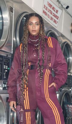 a woman with dreadlocks standing in front of washers