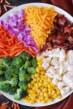 a white plate topped with broccoli, carrots, corn and other foods