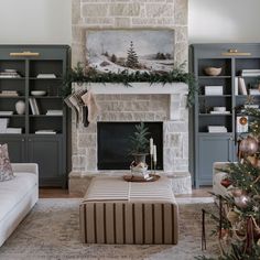 the living room is decorated for christmas and has a large fireplace with stockings on it