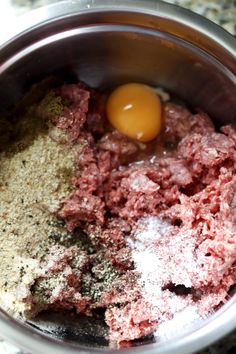 meat and spices in a bowl with an egg