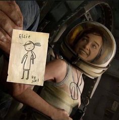 a woman in an astronaut suit holding a piece of paper with the words eliie written on it