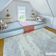 an attic bedroom with white walls and wood flooring