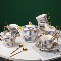 blue and white striped porcelain tea set with gold trimmings on a table top