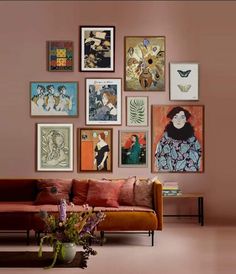 a living room filled with lots of art on the wall above a couch and coffee table