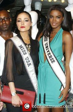 two beautiful women standing next to each other in front of mannequins wearing crowns