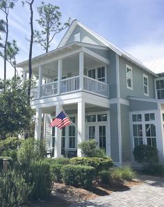 a large gray house with an american flag on the front