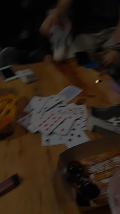 the table is covered with playing cards and chips