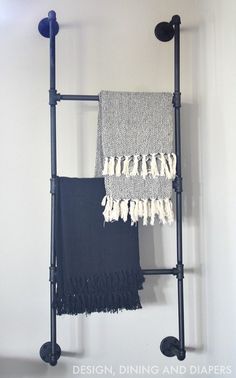 a towel rack with two towels hanging from it's sides and one on the wall