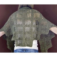 a woman wearing a green crochet top and jeans with her back turned to the camera