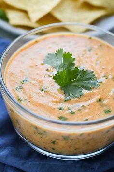 a glass bowl filled with guacamole and garnished with cilantro