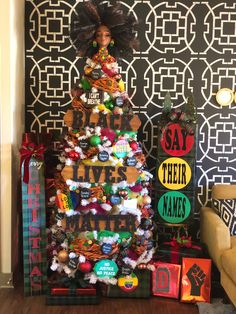 a decorated christmas tree in the corner of a room with black and white wallpaper