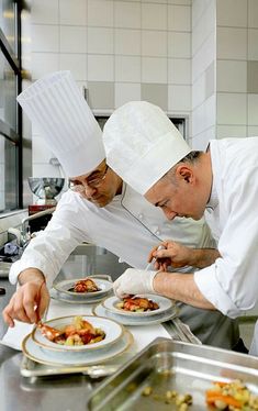 two chefs preparing food in a commercial kitchen