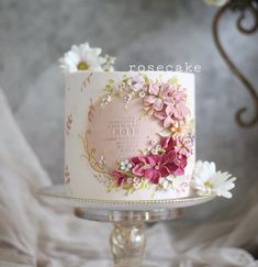 a white cake with pink and yellow flowers on it