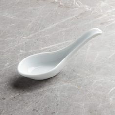 a white spoon sitting on top of a marble counter