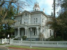 a large white house sitting on the side of a road