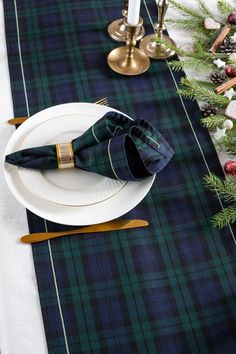 the table is set with plaid napkins and place settings