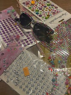 many different types of beads and sunglasses on a table with some tags attached to them