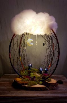 a cloud lamp is sitting on top of a wooden table with moss and other decorations