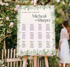 a wooden easer holding a seating chart with flowers on it and a woman standing in the background