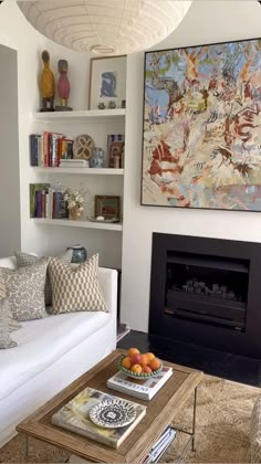 a living room filled with furniture and a fire place next to a wall mounted painting