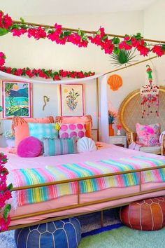 a bedroom decorated in pink, blue and green colors with flowers on the headboard