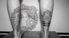 two people with tattoos on their legs standing next to each other