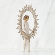 a figurine is standing in front of a white marble wall with a circular mirror