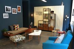 a living room filled with furniture and pictures on the wall next to a coffee table