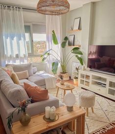 a living room filled with furniture and a flat screen tv mounted on a wall next to a window