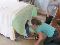 two children are playing in front of a bed made to look like a plane with the door open