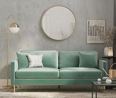 a living room scene with focus on the green couch and round mirror over the sofa