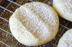 three powdered sugar cookies cooling on a wire rack