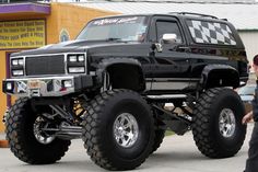 a large black truck parked in front of a building