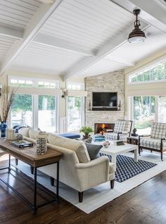 a living room filled with furniture and a flat screen tv mounted on the wall above a fireplace