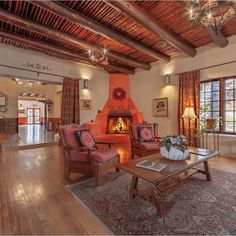 a living room filled with furniture and a fire place in the middle of a room