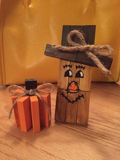 a wooden block with a scarecrow painted on it next to a pumpkin shaped box