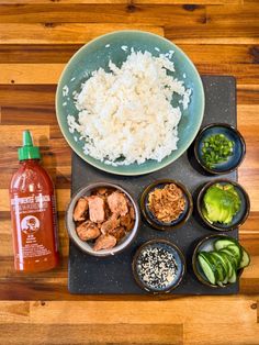 an overhead view of rice, meat and vegetables on a plate next to a bottle of ketchup