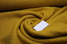 a yellow blanket with a white tag on it