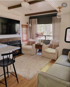 a living room filled with furniture and a flat screen tv mounted to the wall over a fireplace