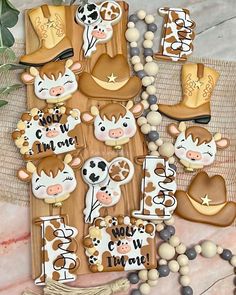 cow themed cookies are arranged on a table with beads and other items to make it look like they have been made out of wood