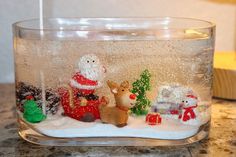 a glass bowl filled with snow and christmas decorations